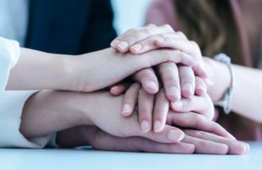 Hands joined together in a supportive gesture